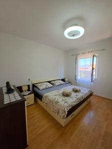 a bedroom with a large bed and a window at Apartman Andrej in Povlja +6 photos