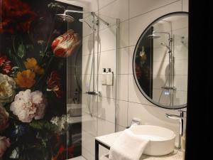 een badkamer met een wastafel en een spiegel bij Hotel Central in Roosendaal