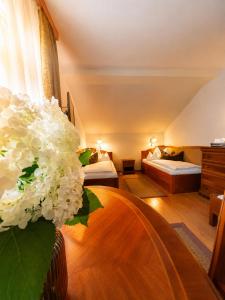 a hotel room with two beds and a vase of flowers at Csiszárhegyi Vadászház in Karád