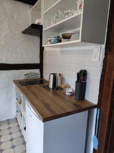 a kitchen with a wooden counter top and white cabinets at Odpocznij -apartament nad jeziorem in Rydzewo