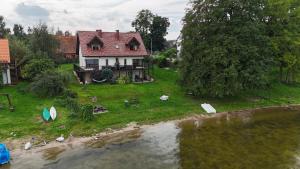 an aerial view of a house next to a river at Odpocznij -apartament nad jeziorem in Rydzewo