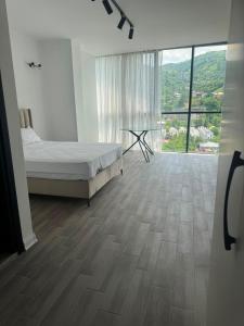 a bedroom with a bed and a large window at Thom Tower in Gonio