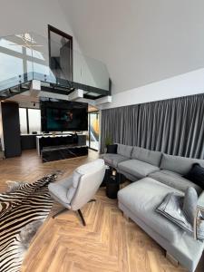 a living room with a couch and a tv at LUMA Lodge in Sadu
