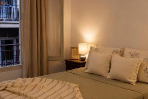 a bedroom with a bed with pillows and a window at Terraza esquina en el centro in Elche