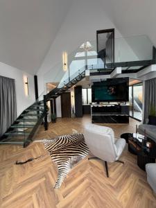 a living room with a staircase and a zebra rug at LUMA Lodge in Sadu