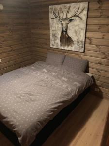 a bed in a room with a picture of a deer at Hansmoen in Bjorli