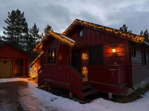 a log cabin with christmas lights on it at Hansmoen in Bjorli