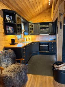 a kitchen with blue cabinets and a wooden ceiling at Hansmoen in Bjorli