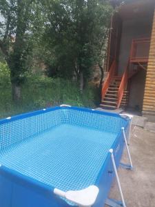 a blue swimming pool with a chair in a yard at Syuzn Resort in Goris +4 photos