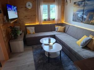 a living room with a couch and a table at Green cottage in Blidinje