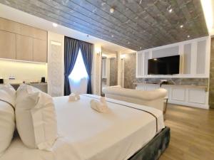 a bedroom with a large white bed with pillows at Frazel Heritage Hotel in Alor Setar