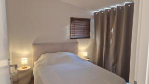 a bedroom with a bed and a shower curtain at Between Calvi and Ile Rousse seaside in Lumio