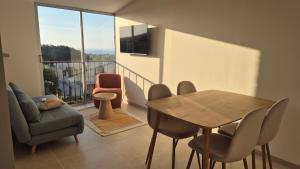 a living room with a table and chairs and a balcony at Between Calvi and Ile Rousse seaside in Lumio