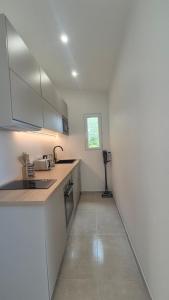 a kitchen with white cabinets and a counter top at Between Calvi and Ile Rousse seaside in Lumio