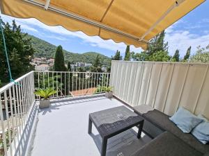 a patio with a couch and a table on a balcony at Meridiens in Dubrovnik