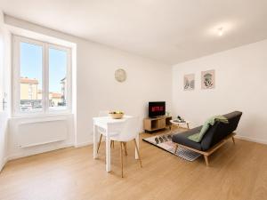 a white living room with a table and a chair at 8A - Le Nid in Saint-Rambert-dʼAlbon