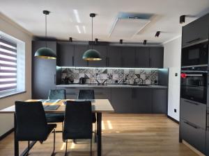a kitchen and dining room with a table and chairs at Apartament Stara cegła 1 i 2 in Głuszyca