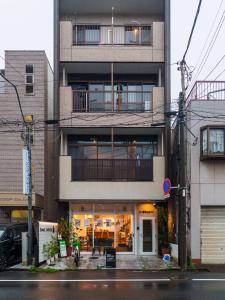 a building with a balcony on the side of it at Bonsai Cafe and Stay - B&B Dormitory in Tokyo