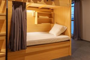 a bunk bed in a room with wooden walls at Bonsai Cafe and Stay - B&B Dormitory in Tokyo +56 photos