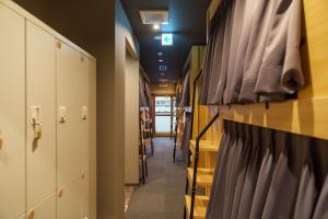 a hallway in a school with lockers and a hallwayngthngthngthngthngth at Bonsai Cafe and Stay - B&B Dormitory in Tokyo