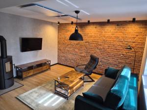 a living room with a blue couch and a brick wall at Apartament Stara cegła 1 i 2 in Głuszyca