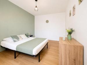 a bedroom with a bed and a wooden table at 8A - Le Nid in Saint-Rambert-dʼAlbon