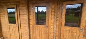 two doors in a log cabin with windows at Mäe Puhkemaja in Rosma
