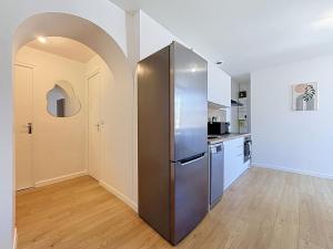 a kitchen with a stainless steel refrigerator in a room at 8A - Le Nid in Saint-Rambert-dʼAlbon