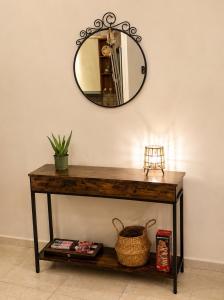 a mirror on a wall above a table with a basket at HOUSE WITH GARDEN Netflix in Néa Kerasiá