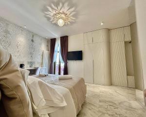 a bedroom with a large bed and a chandelier at La PEPITE in Viareggio