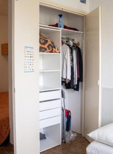 a closet with white drawers and clothes at Studio confortable à Valras-Plage de 26 m² in Valras-Plage