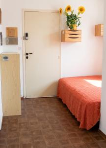 a room with a bed and a vase of flowers on the wall at Studio confortable à Valras-Plage de 26 m² in Valras-Plage