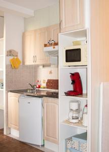 a kitchen with white cabinets and a white microwave at Studio confortable à Valras-Plage de 26 m² in Valras-Plage