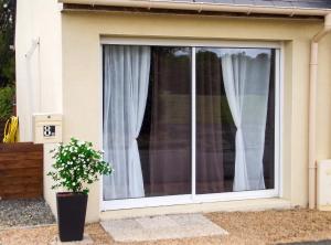 a window with white curtains and a potted plant at Studio confortable à Pédernec - 27m² - Terrasse ensoleillée in Pédernec