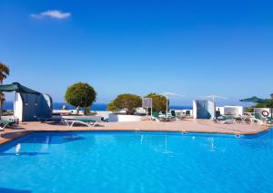 a large blue swimming pool with a view of the ocean at Charming Apartment in Tías + Pool in Tías +23 photos