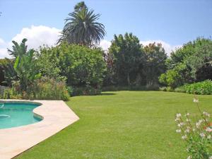a garden with a swimming pool in the grass at Francolin's Rest Guest Suite in Sweet Valley