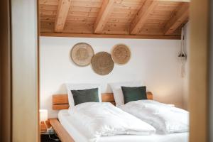 two beds in a room with wooden ceilings at Bergchalet mit Panoramablick nahe Brienz in Axalp