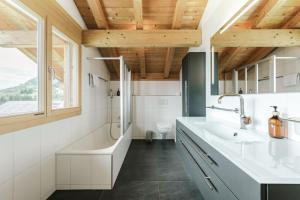 a bathroom with a sink and a tub and a toilet at Bergchalet mit Panoramablick nahe Brienz in Axalp