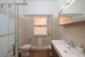 a bathroom with a toilet and a sink and a window at ArticOstia in Lido di Ostia +22 photos
