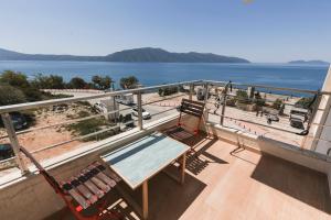 two chairs and a bench on a balcony overlooking the water at Lotus Apartments in Vlorë