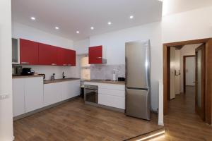 a kitchen with white cabinets and a stainless steel refrigerator at ArticOstia in Lido di Ostia