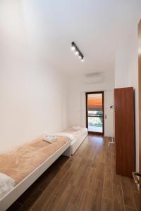 a bedroom with two beds and a wooden floor at ArticOstia in Lido di Ostia