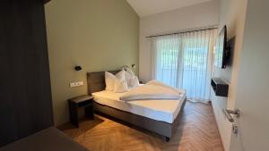 a bedroom with a bed with white sheets and a window at Mountain Inn - Hochquartier - Wildschönau in Niederau