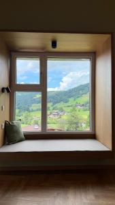 a window seat with a view of a mountain view at Mountain Inn - Hochquartier - Wildschönau in Niederau