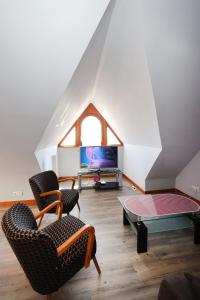 a living room with two chairs and a table at Gîte sous le toit du vigneron in Epfig