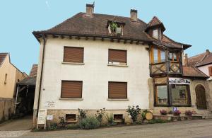 a large white house with a brown roof at Gîte sous le toit du vigneron in Epfig
