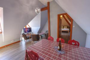 a dining room with a table with a wine bottle on it at Gîte sous le toit du vigneron in Epfig