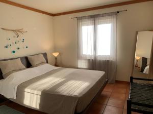 a bedroom with a large bed and a window at Aldeamento Turistico Casas da Comporta in Comporta +69 photos