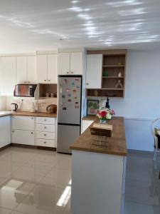 a kitchen with white cabinets and a refrigerator at The Willow Escape in Ballito +7 photos