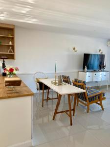 a living room with a table and chairs and a tv at The Willow Escape in Ballito